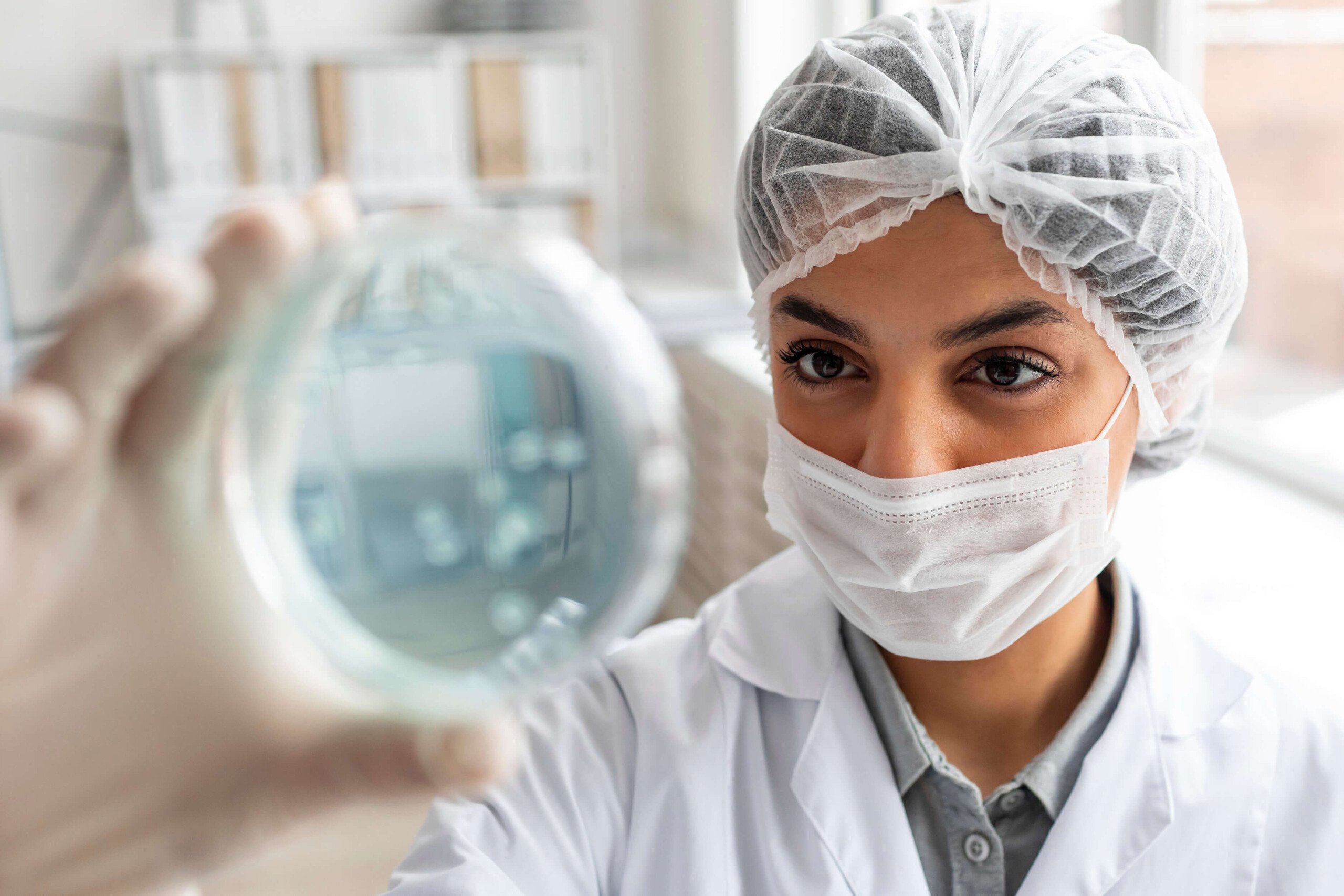 A lab worker looking at an object. 